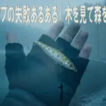 冬トップが釣れない理由を象徴する、冬の湖とルアーを持つ手のイメージ画像。木を見て森を見ずという視点を表現。